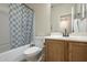 Bathroom featuring a shower-tub combo with a tile surround and a oak vanity at 7525 W Springfield Way, Florence, AZ 85132