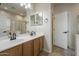 Bathroom with dual sinks, a framed mirror, wood cabinets, and a separate toilet room at 7525 W Springfield Way, Florence, AZ 85132