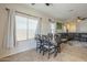 Bright dining area with a modern table set, windows with blinds, and tile flooring at 7525 W Springfield Way, Florence, AZ 85132