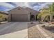 Inviting single-story home with a two-car garage, desert landscaping, and a charming walkway at 7525 W Springfield Way, Florence, AZ 85132