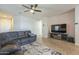 Comfortable living room with a large sectional sofa, ceiling fan, and neutral color scheme at 7525 W Springfield Way, Florence, AZ 85132