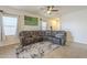 Inviting living room showcasing a large sectional sofa, ceiling fan, and plenty of natural light at 7525 W Springfield Way, Florence, AZ 85132