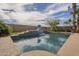 Backyard pool with waterfall, sports hoop, and patio, perfect for outdoor entertainment at 7525 W Springfield Way, Florence, AZ 85132