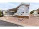 Inviting manufactured home features desert landscaping and a brick-paved driveway leading to a covered carport at 7750 E Broadway Rd # 54, Mesa, AZ 85208