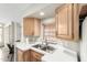 Well-lit kitchen featuring a stainless steel sink, window with blinds, and ample cabinet space at 7750 E Broadway Rd # 54, Mesa, AZ 85208