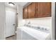 Bright laundry room with modern, white appliances and wood cabinetry for storage at 7750 E Broadway Rd # 54, Mesa, AZ 85208