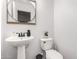 Clean powder room with a pedestal sink, modern fixtures, and a water-efficient toilet at 7840 W Bonitos Dr, Phoenix, AZ 85035