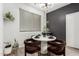 Chic dining area with a modern table, stylish lighting, and serene window views at 7840 W Bonitos Dr, Phoenix, AZ 85035