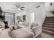 Open-concept living room with a comfortable sofa, connecting seamlessly to the modern kitchen and staircase at 7840 W Bonitos Dr, Phoenix, AZ 85035