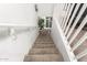 Carpeted staircase with white railings and a view of a decorative plant at 7840 W Bonitos Dr, Phoenix, AZ 85035