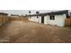 A expansive dirt backyard with a white house and newly installed wood fence at 7955 W Mackenzie Dr, Phoenix, AZ 85033