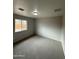 A minimalist bedroom with plush carpeting and a window view into the backyard at 7955 W Mackenzie Dr, Phoenix, AZ 85033