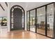 Elegant foyer with a dark arched door, light wood floors, and an office with glass doors at 8005 N Via De Lago --, Scottsdale, AZ 85258