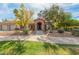 Charming single-story home with a brick archway entry, desert landscaping, and a lush green lawn at 8005 N Via De Lago --, Scottsdale, AZ 85258