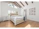 Airy main bedroom featuring beamed ceilings, hardwood floors, and plantation shutters at 8005 N Via De Lago --, Scottsdale, AZ 85258