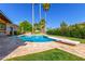 Backyard swimming pool with a diving board, surrounded by a patio, trees, flowers and lush greenery at 8005 N Via De Lago --, Scottsdale, AZ 85258