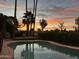 Beautiful backyard pool reflecting a vibrant sunset, surrounded by lush landscaping at 8005 N Via De Lago --, Scottsdale, AZ 85258