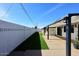 Wide backyard with dark metal shade structure, white walls, and green grass at 8335 E Montecito Ave, Scottsdale, AZ 85251