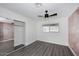 This bedroom features gray floors, a ceiling fan, window, and a mirrored closet at 8335 E Montecito Ave, Scottsdale, AZ 85251