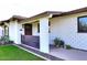 Charming single-story home with textured white brick, a gated porch, and manicured landscaping at 8335 E Montecito Ave, Scottsdale, AZ 85251