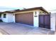 View of a one car garage with brick details and a small entry gate on a sunny day at 8335 E Montecito Ave, Scottsdale, AZ 85251