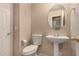 Compact powder room features a pedestal sink, toilet, and neutral wall color at 835 E Stirrup Ln, San Tan Valley, AZ 85143