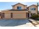 Two story home featuring a tile roof, three car garage, and neutral desert landscaping at 835 E Stirrup Ln, San Tan Valley, AZ 85143