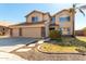 Two story home featuring a tile roof, three car garage, desert landscaping, and walkway at 835 E Stirrup Ln, San Tan Valley, AZ 85143