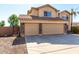 A three car garage featuring tan doors, stone accents, and a concrete driveway at 835 E Stirrup Ln, San Tan Valley, AZ 85143