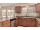 Kitchen area featuring granite countertops, wooden cabinets, and stainless steel dishwasher at 835 E Stirrup Ln, San Tan Valley, AZ 85143