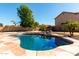 Inviting backyard pool with rock waterfall feature and mature landscaping on a sunny day at 835 E Stirrup Ln, San Tan Valley, AZ 85143