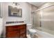 Bathroom with a tile shower-tub combo, granite-topped vanity, brushed-nickel fixtures, and decorative mirror at 8538 E Vista Dr, Scottsdale, AZ 85250