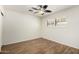 White bedroom with wood-look floors, a contemporary ceiling fan, and a window with wood shutters at 8538 E Vista Dr, Scottsdale, AZ 85250