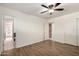 Large bedroom with wood-look floors, ceiling fan, and doorways to a kitchen and closet areas at 8538 E Vista Dr, Scottsdale, AZ 85250