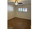 Bright bedroom featuring a ceiling fan, wood-look floors, and window with shutters at 8538 E Vista Dr, Scottsdale, AZ 85250