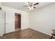 Open bedroom with wood-look floors, a ceiling fan, and a closet and doorway with classic white doors at 8538 E Vista Dr, Scottsdale, AZ 85250