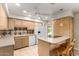 Bright kitchen featuring light wood cabinets, white appliances, tile countertops, and a breakfast bar with seating at 8538 E Vista Dr, Scottsdale, AZ 85250