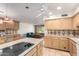 Spacious kitchen features light wood cabinets, tile countertops, island cooktop, and views into an adjacent living space at 8538 E Vista Dr, Scottsdale, AZ 85250