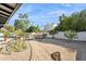 Beautiful desert landscaped backyard with outdoor kitchen, bar seating area and gravel pathway at 8709 E Mackenzie Dr, Scottsdale, AZ 85251