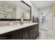 Bathroom featuring double sink vanity, large mirror, and view to outdoor patio at 8709 E Mackenzie Dr, Scottsdale, AZ 85251