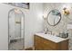 Stylish bathroom featuring a unique mirror, modern vanity, and decorative tiled floor at 8709 E Mackenzie Dr, Scottsdale, AZ 85251