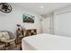 Bright bedroom featuring sleek white walls, modern TV, shelving, and a cozy chair at 8709 E Mackenzie Dr, Scottsdale, AZ 85251