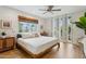 Light and bright bedroom with hardwood floors, ceiling fan and white shutters at 8709 E Mackenzie Dr, Scottsdale, AZ 85251