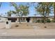 Charming single-story home featuring desert landscaping, a black garage door, and a welcoming walkway at 8709 E Mackenzie Dr, Scottsdale, AZ 85251