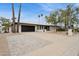 Attractive home exterior with manicured lawn, large driveway and palm trees at 8709 E Mackenzie Dr, Scottsdale, AZ 85251