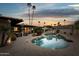 Backyard oasis featuring a sparkling pool, palm trees, lounge chairs, and an inviting patio area at 8709 E Mackenzie Dr, Scottsdale, AZ 85251