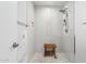 Modern walk-in shower featuring white tile, and a wooden bench at 8709 E Mackenzie Dr, Scottsdale, AZ 85251