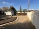 Spacious backyard with a shed, wooden platform, and block wall, offering potential for outdoor living and landscaping at 9033 N 15Th Dr, Phoenix, AZ 85021