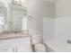 Bright bathroom with granite vanity top, white cabinets, and tile flooring near the bathtub at 9033 N 15Th Dr, Phoenix, AZ 85021