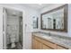 Bathroom featuring granite countertop, framed mirror and a view into the glass enclosed shower and toilet at 9275 E Mission Ln # 206, Scottsdale, AZ 85258